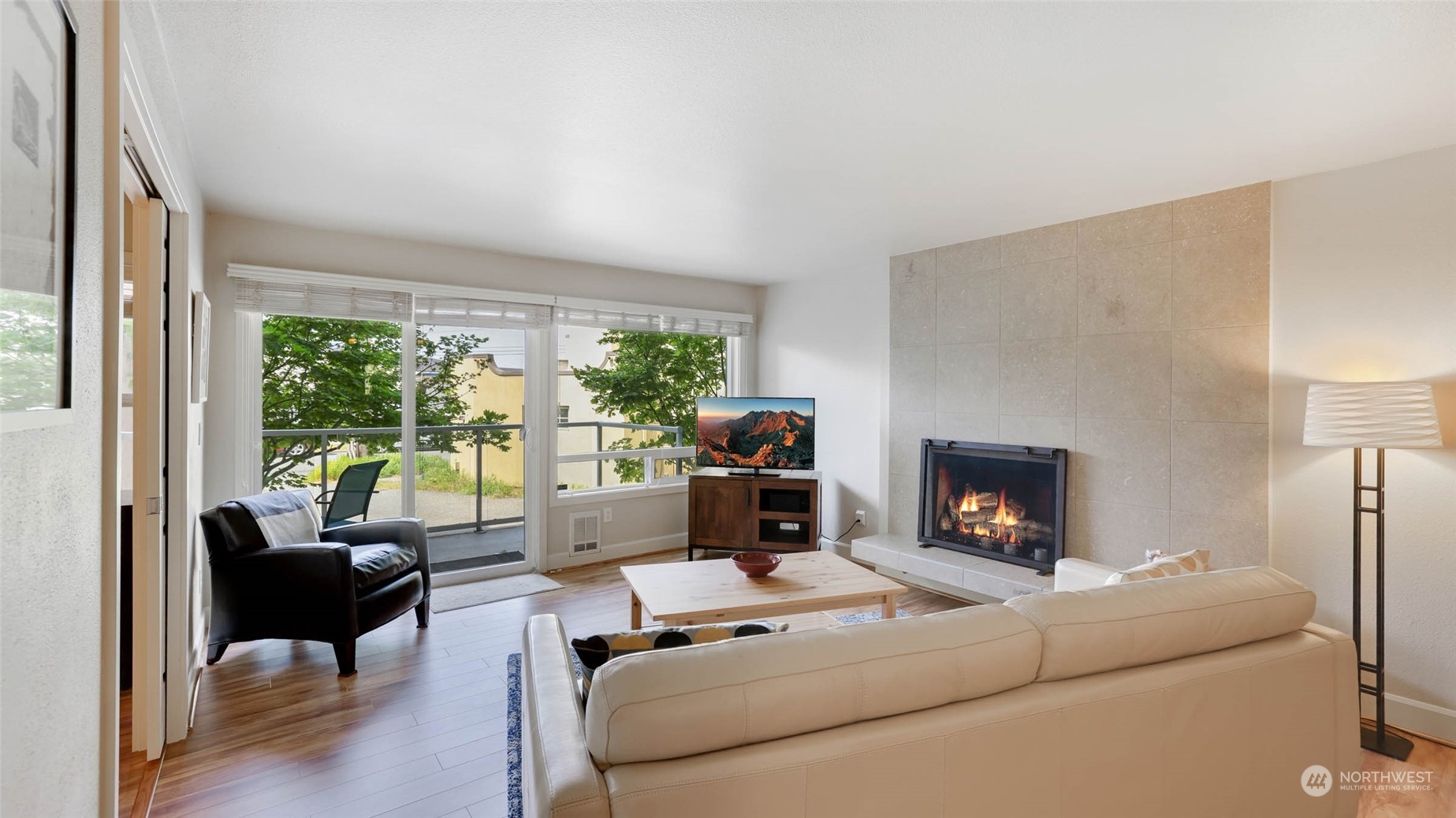 2514 57th Avenue Southwest, Unit 102 Seattle, WA 98116 - Photo 5 of 18 a living room with furniture a large window and a fireplace