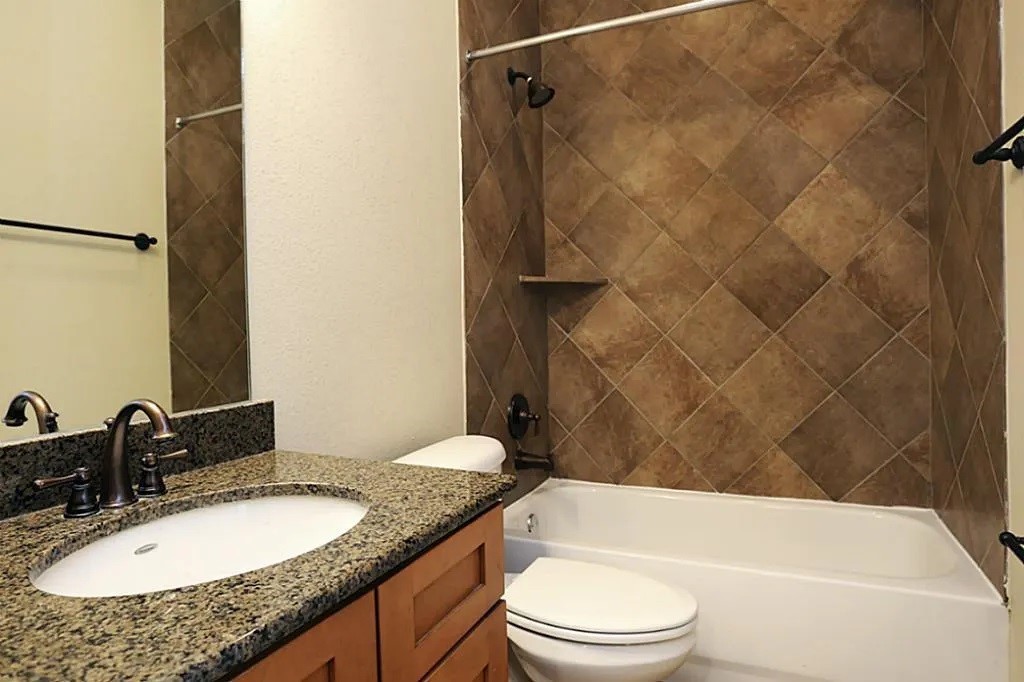 5615 Winsome Lane, Unit H Houston, TX 77057 - Photo 17 of 24 a bathroom with a granite countertop sink toilet and shower
