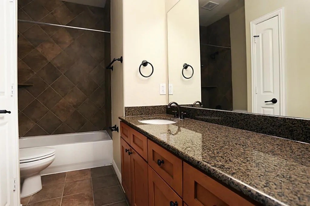 5615 Winsome Lane, Unit H Houston, TX 77057 - Photo 18 of 24 a bathroom with a granite countertop sink a toilet and shower