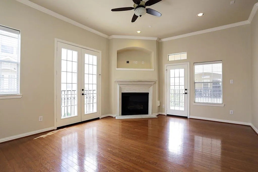 5615 Winsome Lane, Unit H Houston, TX 77057 - Photo 9 of 24 a view of a livingroom with a fireplace wooden floor and windows