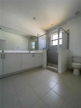 a view of an empty room with window and cabinet