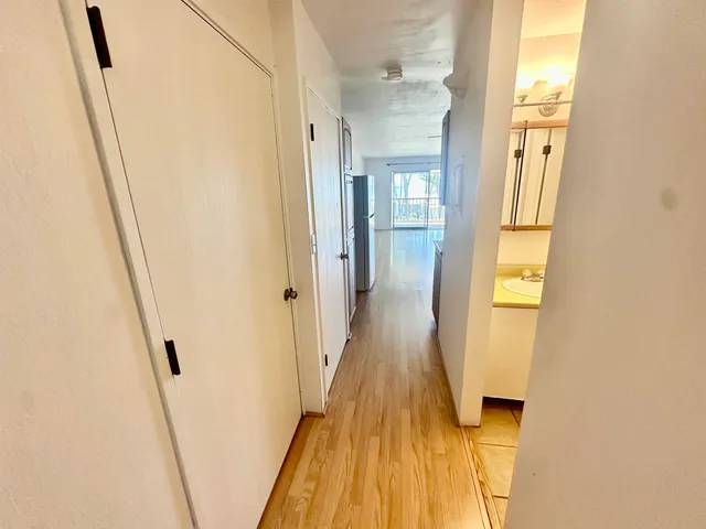 a view of a hallway with wooden floor and staircase