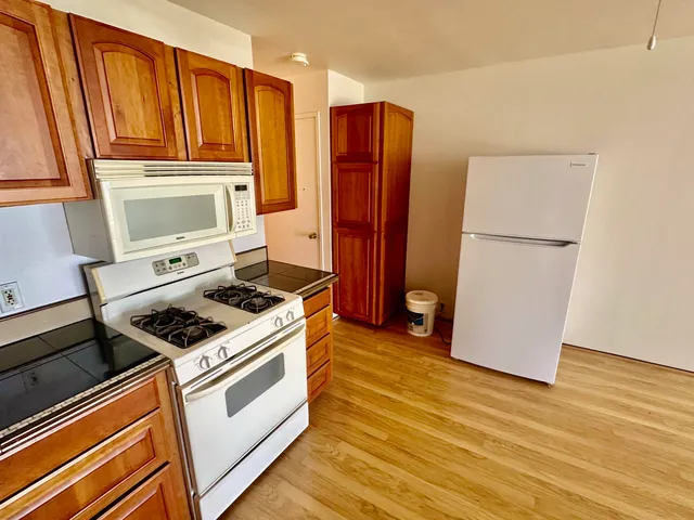a kitchen with stainless steel appliances a stove a refrigerator and cabinets