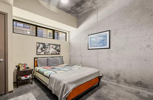 a bedroom with a bed and a painting on the wall