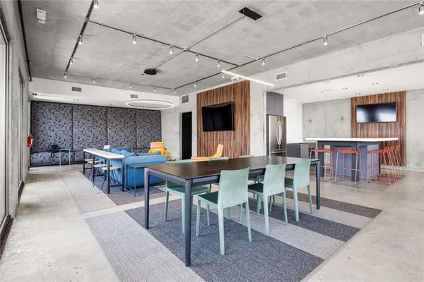 a kitchen with stainless steel appliances a table chairs and a refrigerator