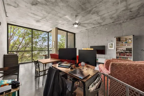 a view of a workspace with furniture and a window