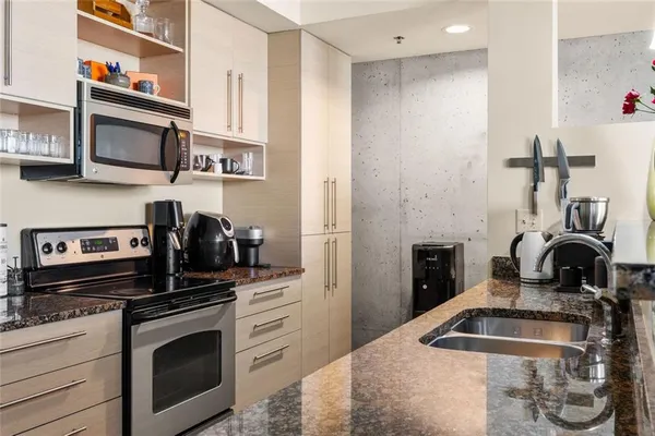 a kitchen with stainless steel appliances granite countertop a sink stove and refrigerator