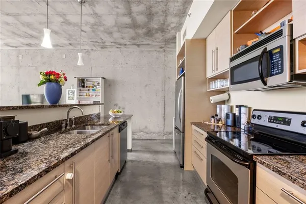 a kitchen with stainless steel appliances granite countertop a sink stove and cabinets