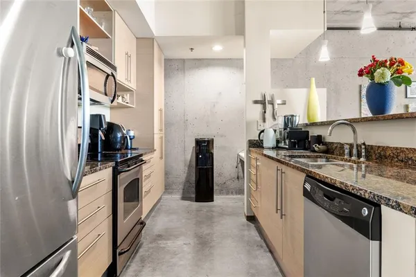 a kitchen with stainless steel appliances granite countertop a sink and a stove