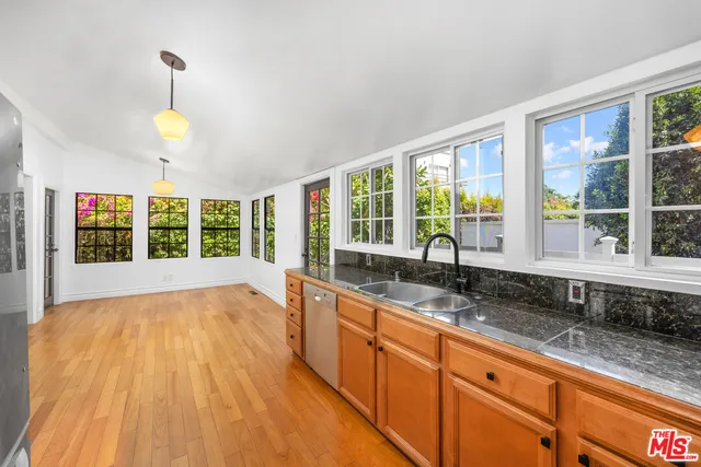 a view of kitchen with stainless steel appliances kitchen island wooden floor and refrigerator