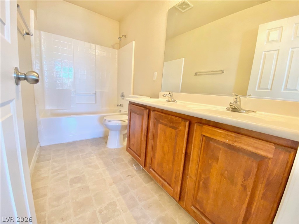 8569 Rhamus Court Las Vegas, NV 89149 - Photo 16 of 35 A well-appointed bathroom features a practical double vanity and a classic shower-tub combination.