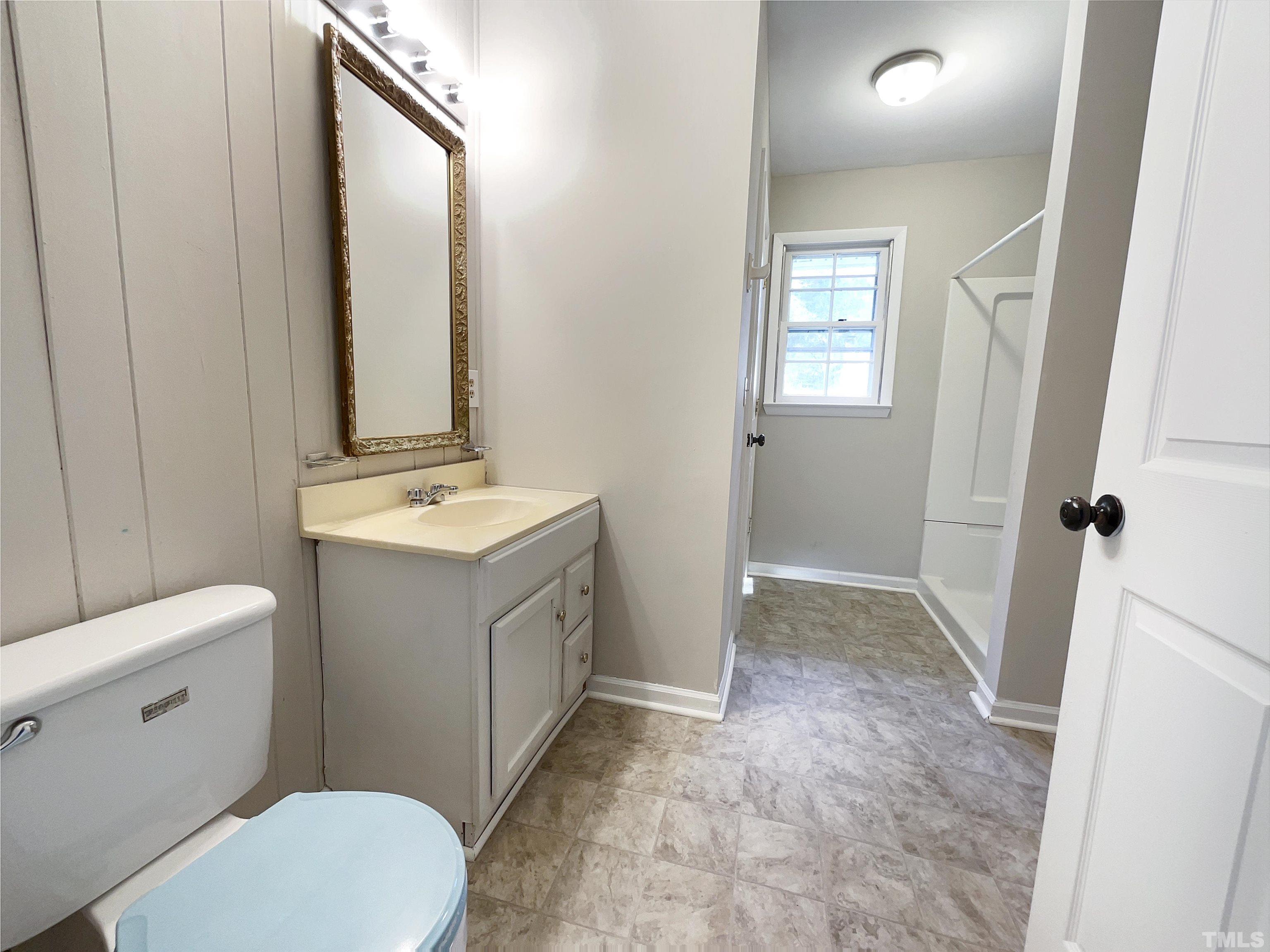 2521 Little John Road Raleigh, NC 27610 - Photo 13 of 18 a bathroom with a sink a toilet a mirror and vanity