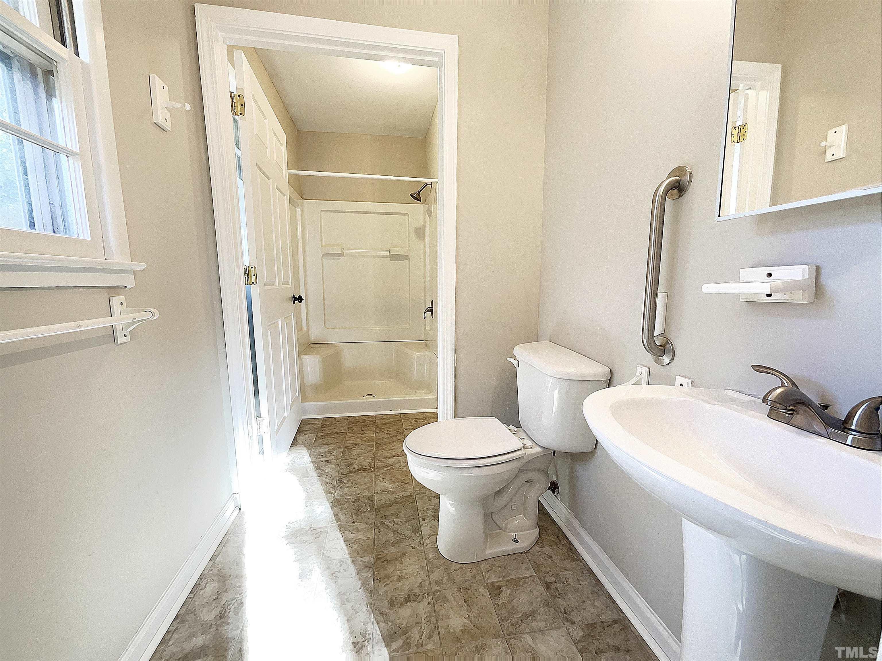 2521 Little John Road Raleigh, NC 27610 - Photo 14 of 18 a bathroom with a white toilet sitting next to a bathroom sink