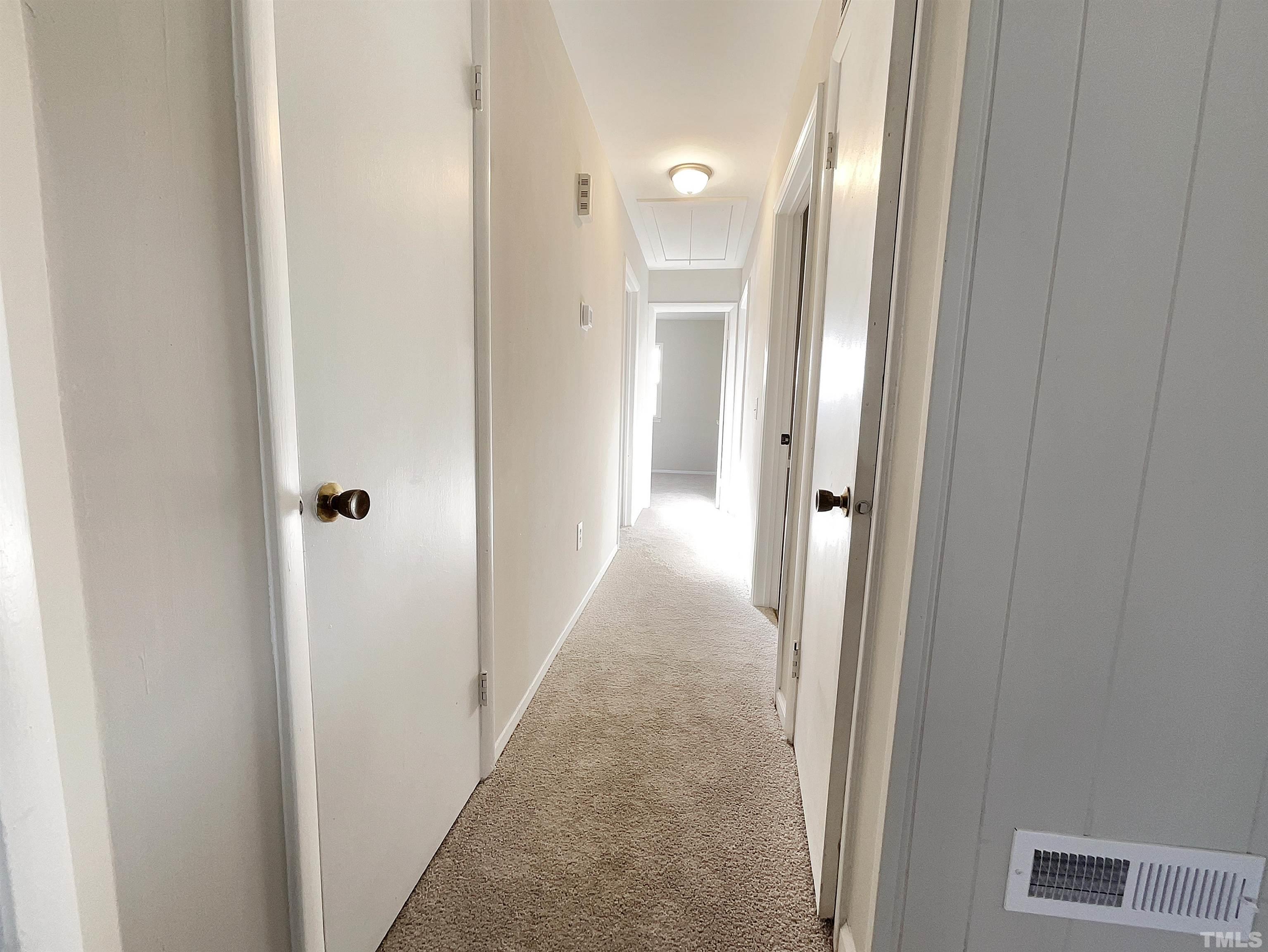 2521 Little John Road Raleigh, NC 27610 - Photo 4 of 18 a view of a hallway with wooden floor and a bathroom