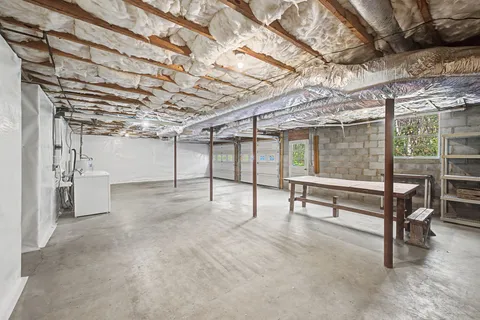 a view of a room with a wooden table and chairs