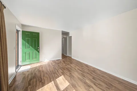 a view of a livingroom with wooden floor and entryway