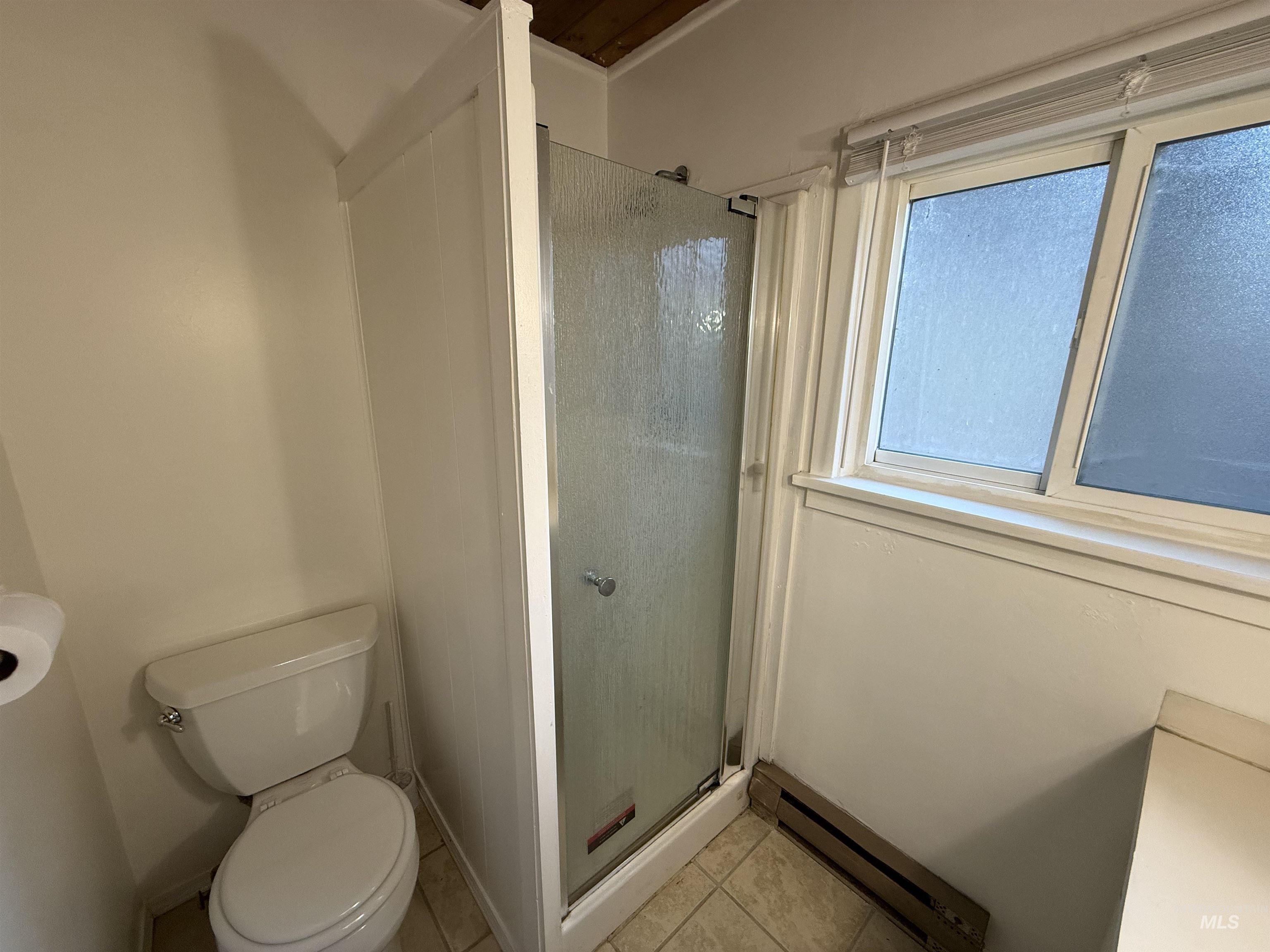 620 Riverside Avenue Orofino, ID 83544 - Photo 7 of 12 Bathroom with a baseboard heating unit, a stall shower, and light tile patterned floors