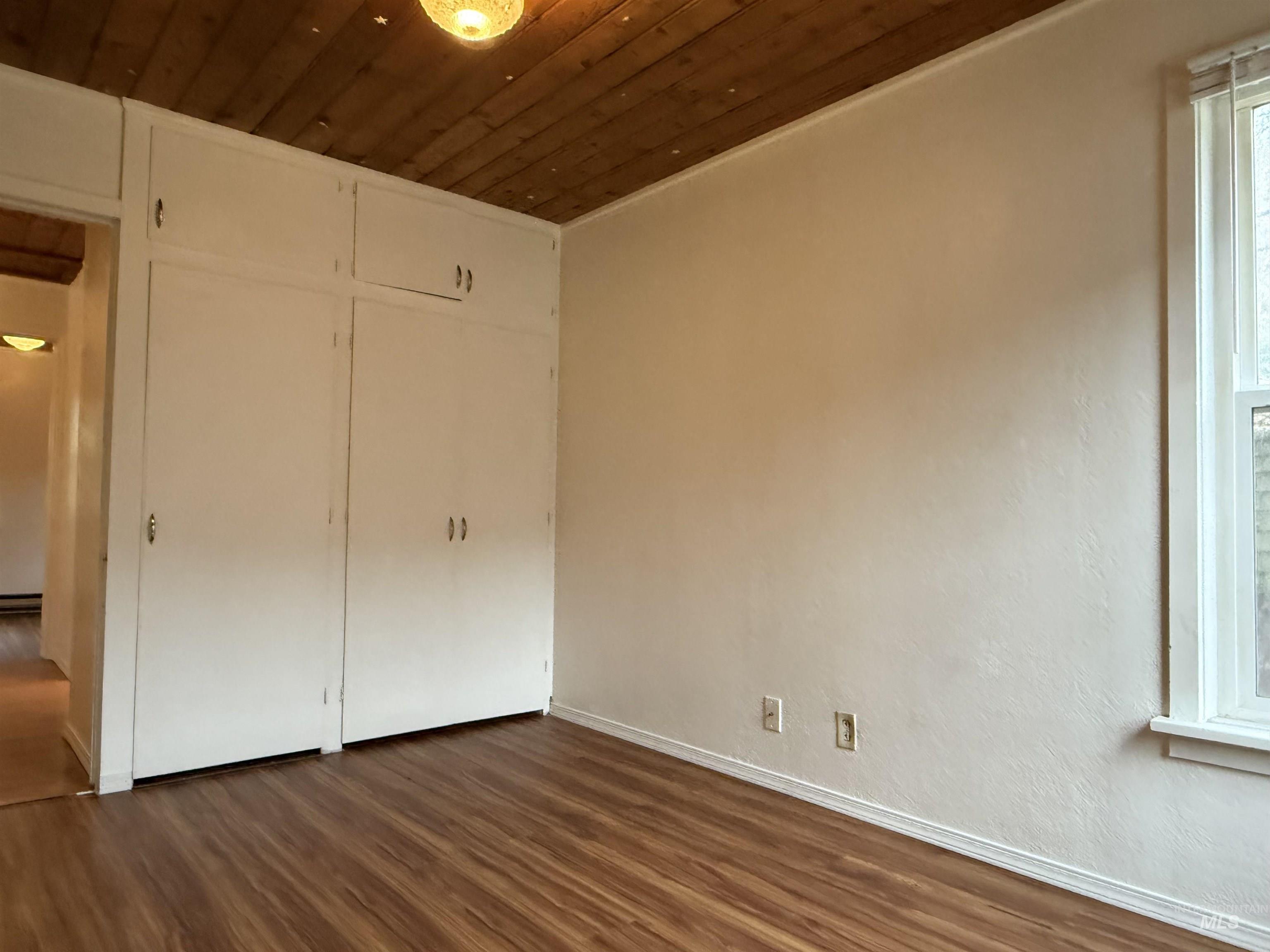 620 Riverside Avenue Orofino, ID 83544 - Photo 9 of 12 Unfurnished bedroom with wooden ceiling, dark wood-style flooring, and a closet