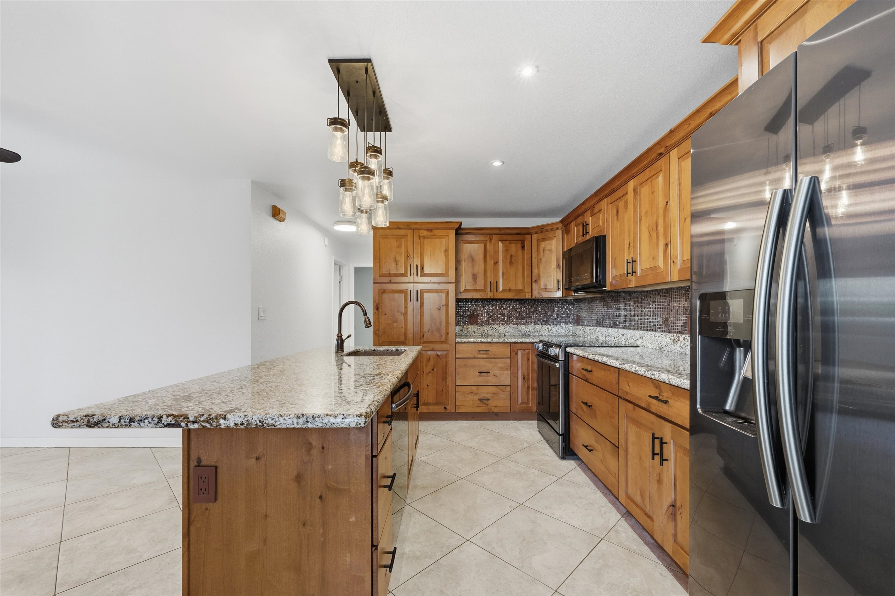140 Uwapo Road, Unit 39101 Kihei, HI 96753 - Photo 11 of 35 a kitchen with stainless steel appliances granite countertop a sink refrigerator and cabinets