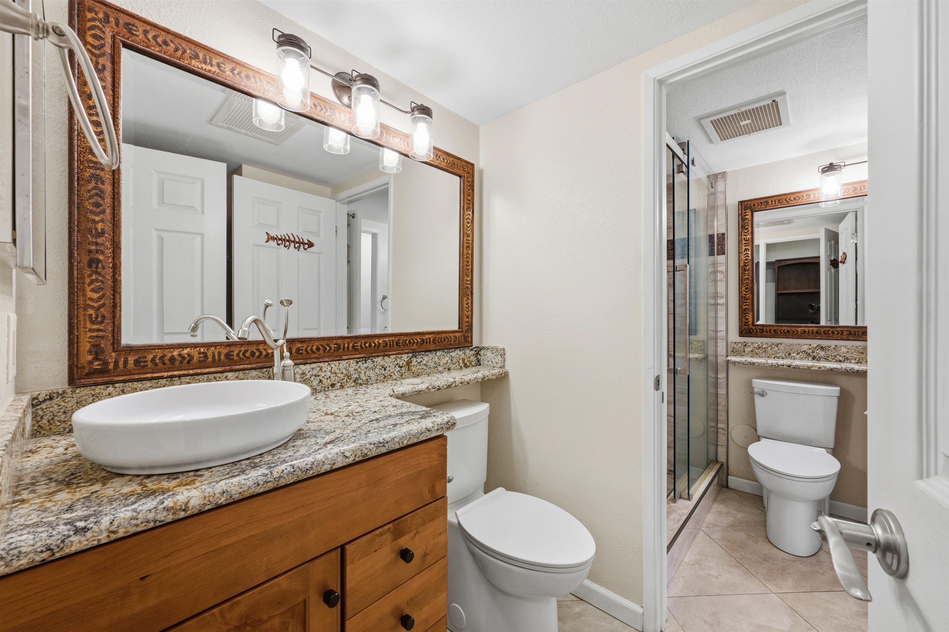 140 Uwapo Road, Unit 39101 Kihei, HI 96753 - Photo 16 of 35 a bathroom with a granite countertop toilet a sink and a mirror