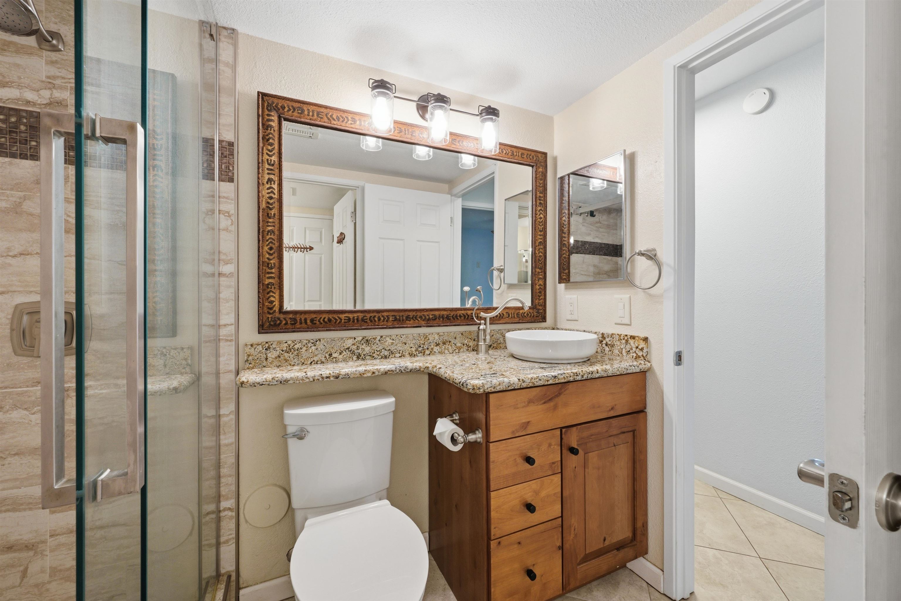 140 Uwapo Road, Unit 39101 Kihei, HI 96753 - Photo 18 of 35 a bathroom with a granite countertop toilet sink and mirror