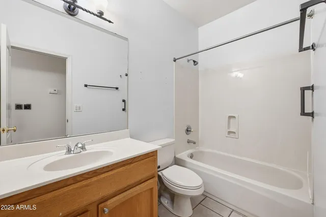 a bathroom with a granite countertop sink a toilet a mirror a bathtub and shower