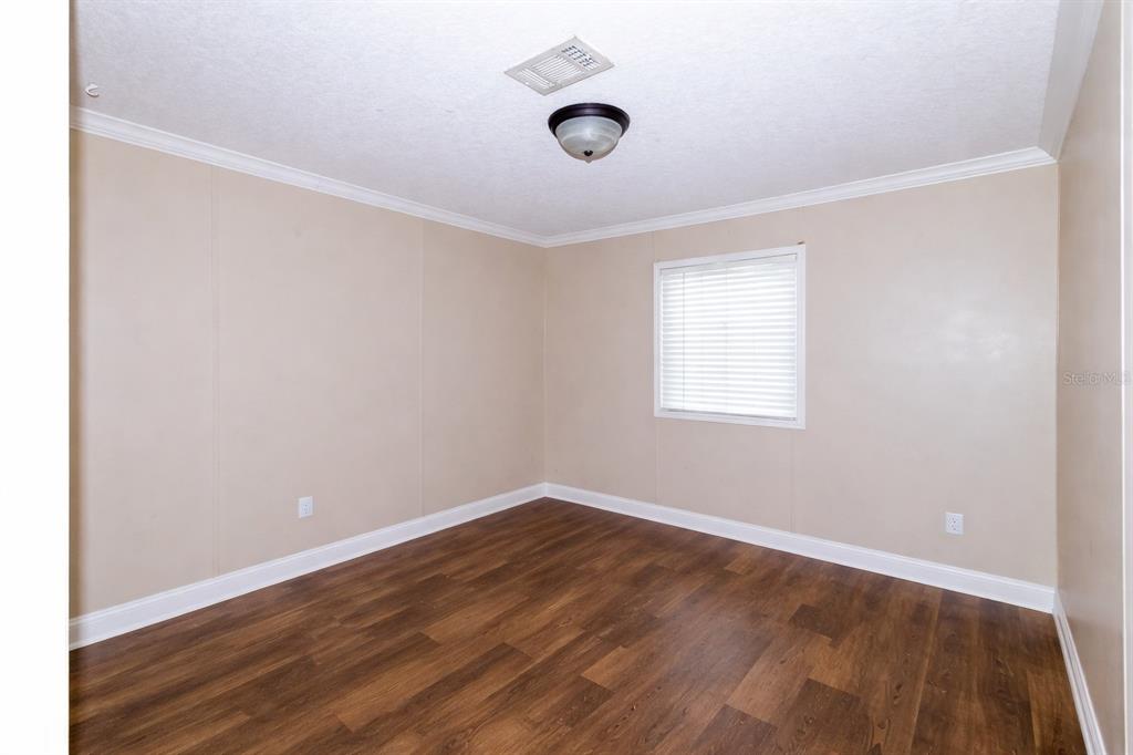 18057 Southwest 37th Street Dunnellon, FL 34432 - Photo 8 of 9 an empty room with wooden floor and windows