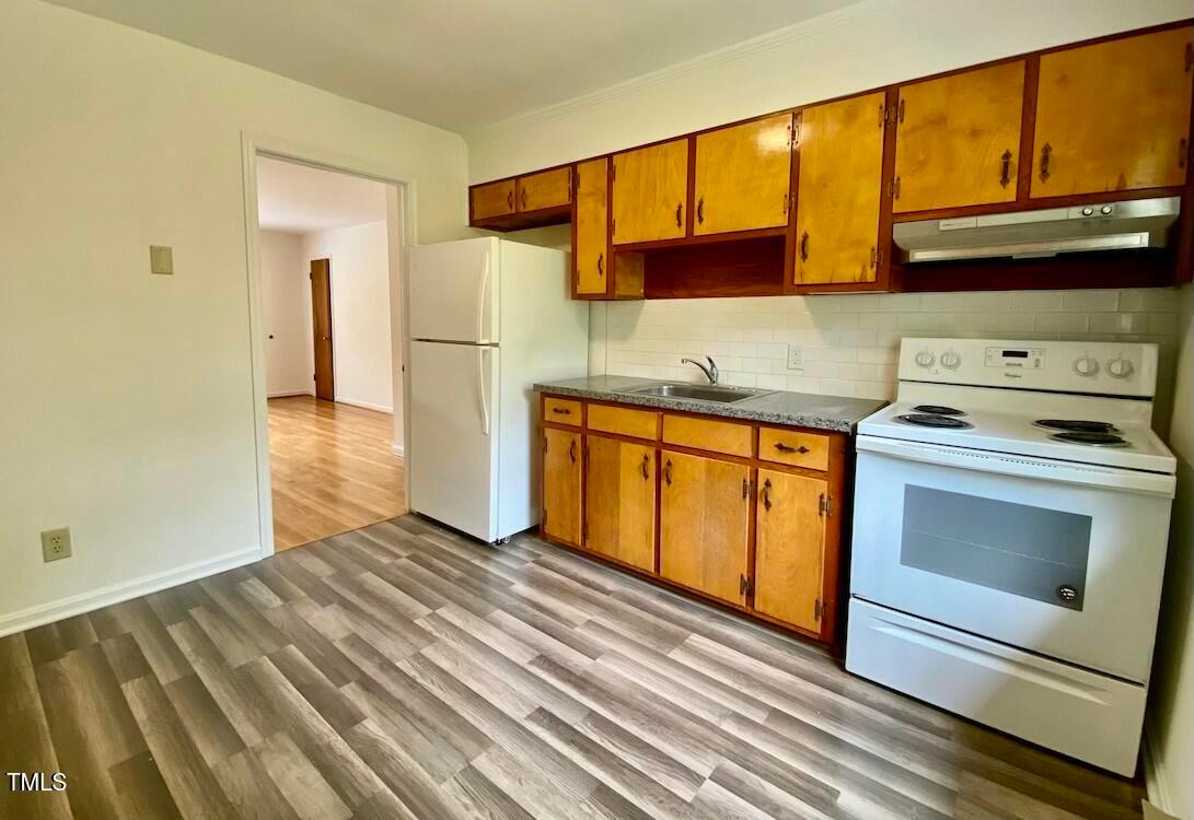 808 North Buchanan Boulevard, Unit B Durham, NC 27701 - Photo 11 of 23 a kitchen with a stove top oven cabinets and a refrigerator