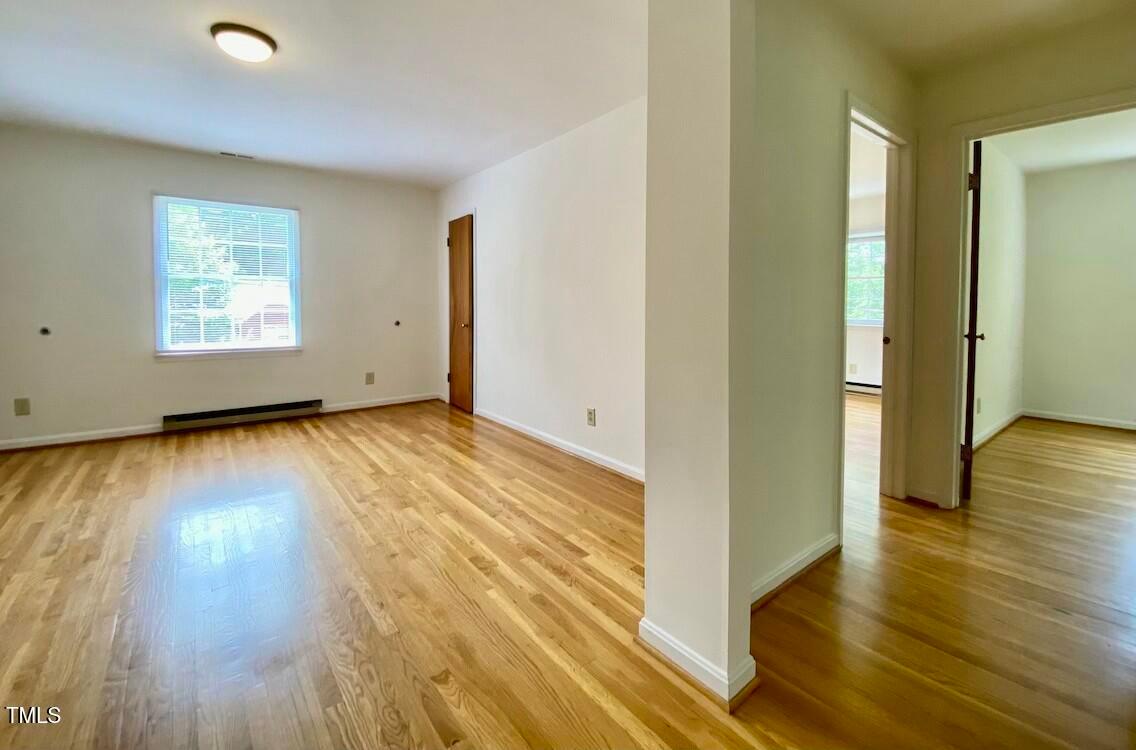 808 North Buchanan Boulevard, Unit B Durham, NC 27701 - Photo 13 of 23 an empty room with wooden floor and windows