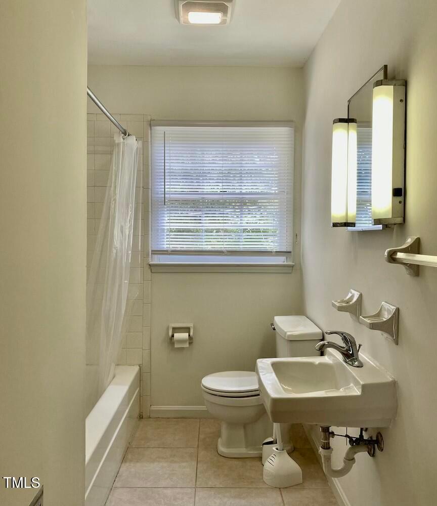 808 North Buchanan Boulevard, Unit B Durham, NC 27701 - Photo 14 of 23 a bathroom with a toilet a sink and mirror