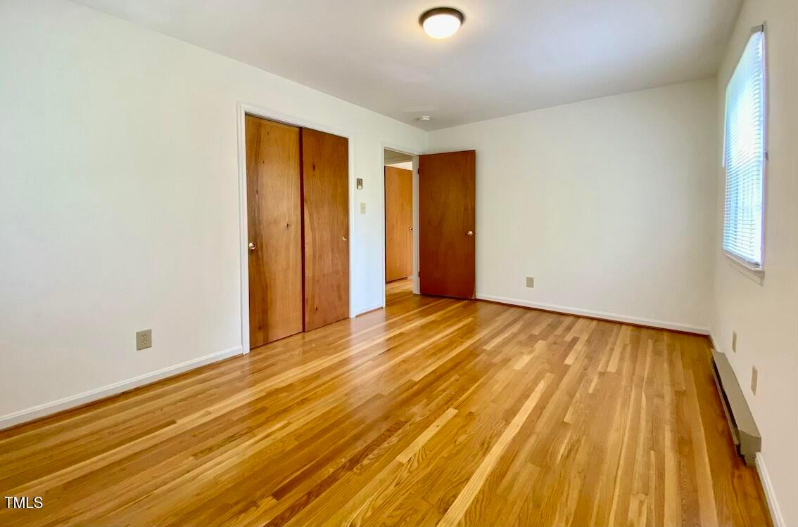 808 North Buchanan Boulevard, Unit B Durham, NC 27701 - Photo 17 of 23 an empty room with wooden floor and windows