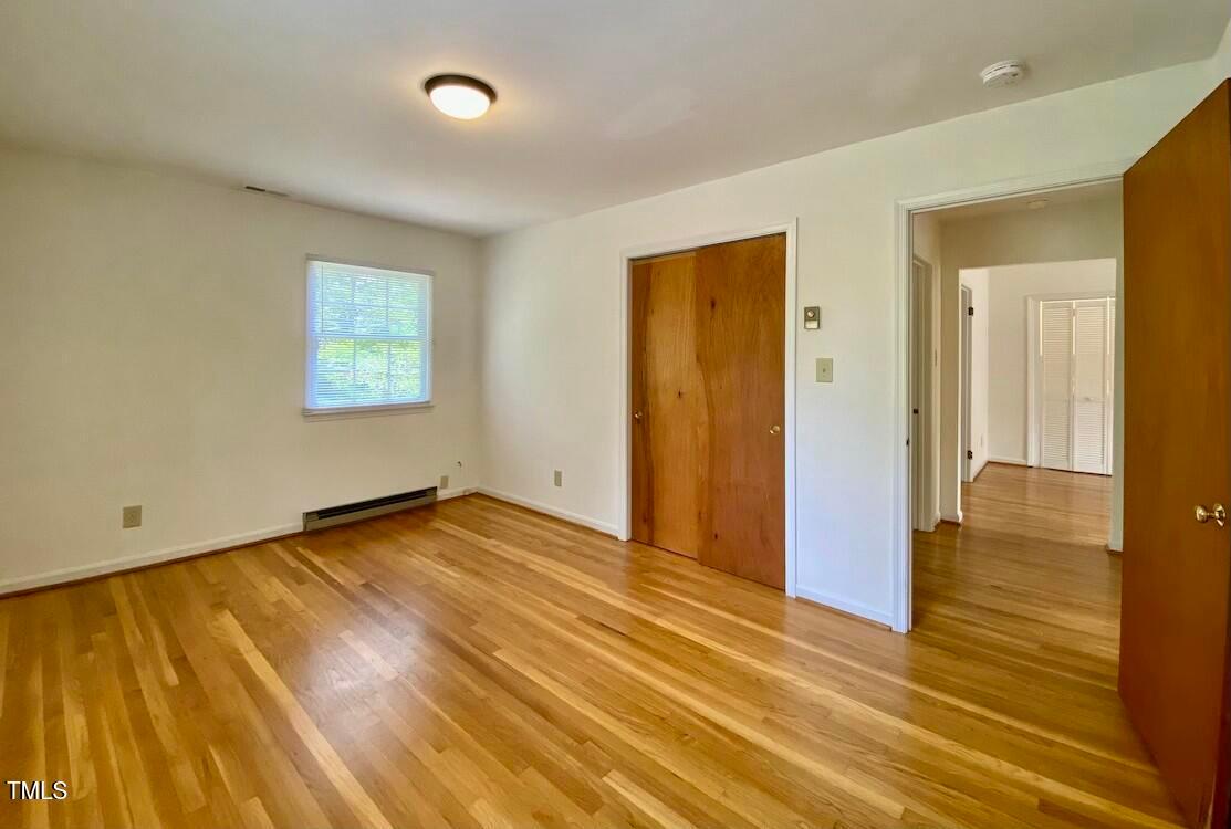 808 North Buchanan Boulevard, Unit B Durham, NC 27701 - Photo 18 of 23 a view of an empty room with wooden floor and a window