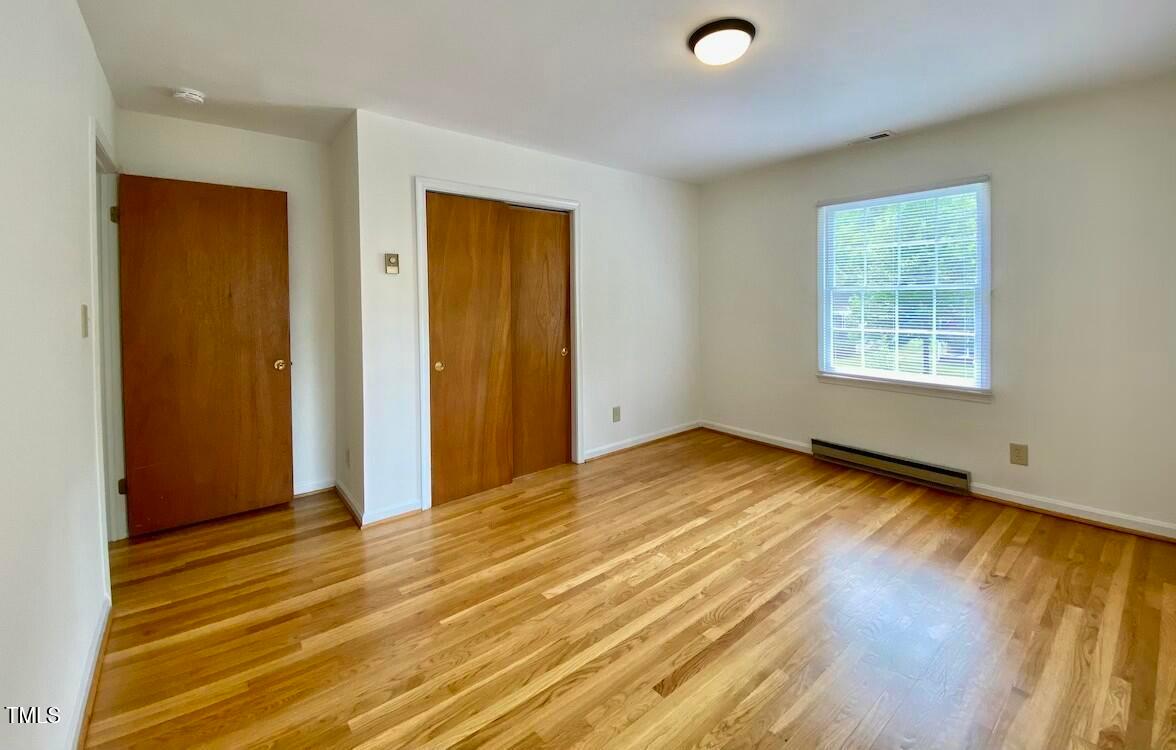 808 North Buchanan Boulevard, Unit B Durham, NC 27701 - Photo 21 of 23 a view of an empty room with wooden floor and a window