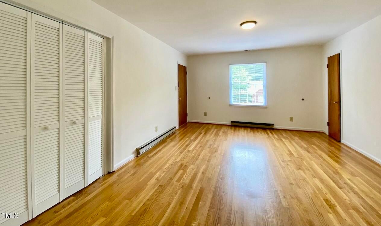 808 North Buchanan Boulevard, Unit B Durham, NC 27701 - Photo 6 of 23 a view of an empty room with wooden floor and a window