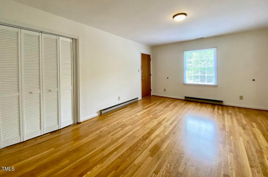 808 North Buchanan Boulevard, Unit B Durham, NC 27701 - Photo 7 of 23 an empty room with wooden floor and windows