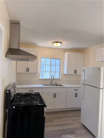 a kitchen with a stove a refrigerator and a sink