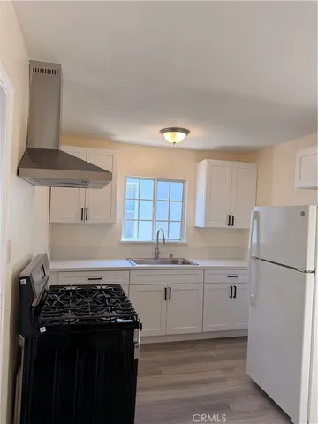 a kitchen with a stove a refrigerator and a sink