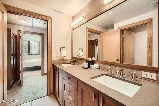 a bathroom with a sink vanity granite tub and a mirror