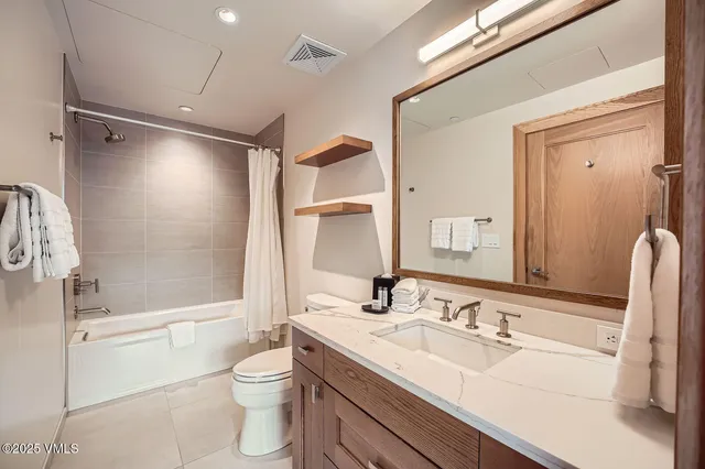 a bathroom with a double vanity sink toilet mirror and shower