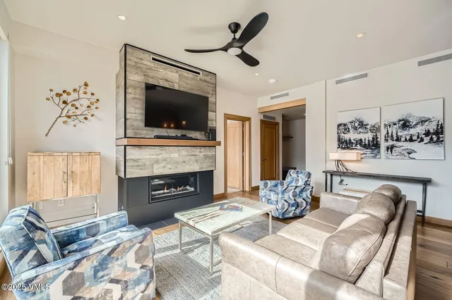 a living room with furniture a flat screen tv and a fireplace