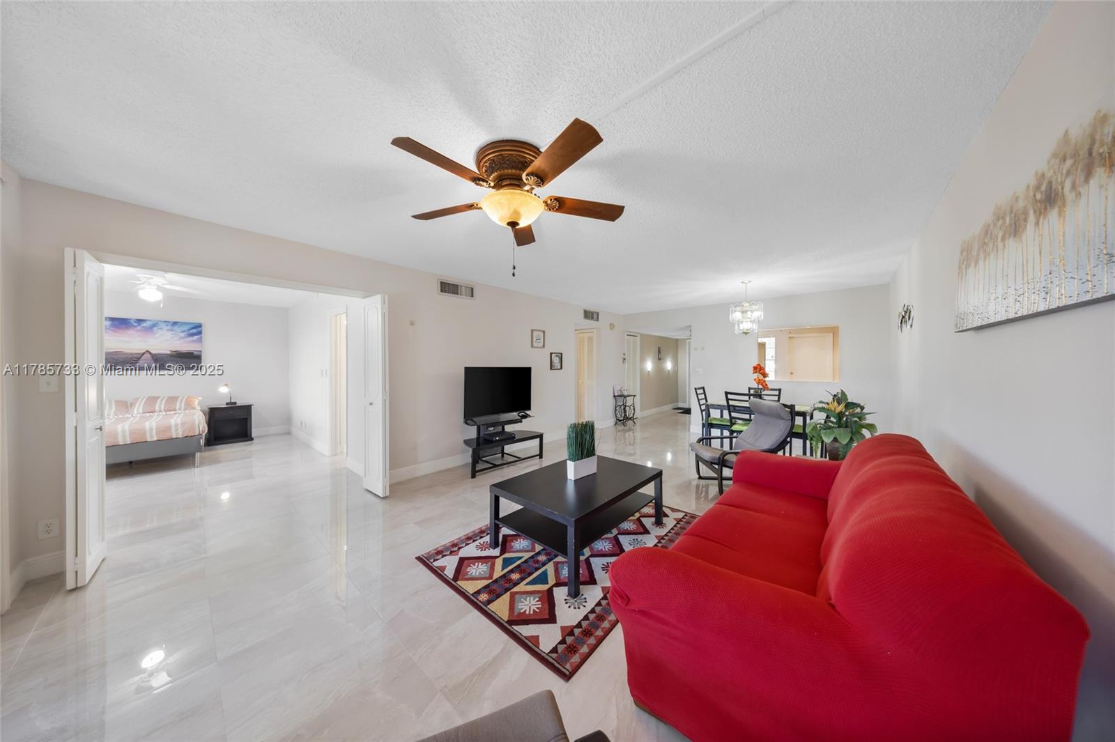 Palm Aire Pompano Beach, FL 33069 - Photo 11 of 27 a living room with furniture a flat screen tv and a chandelier