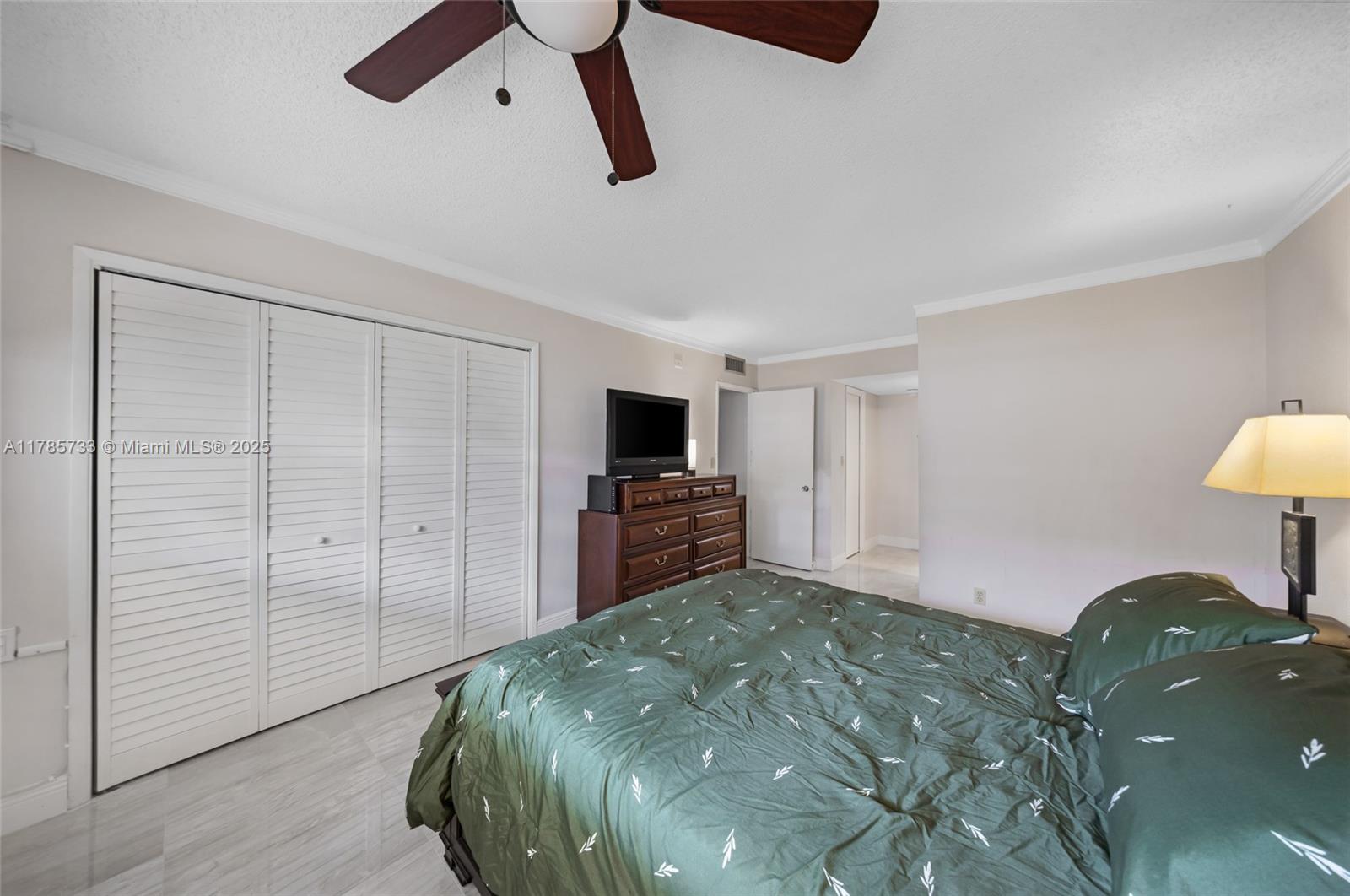 Palm Aire Pompano Beach, FL 33069 - Photo 14 of 27 a bedroom with a bed and a flat tv screen on the wall