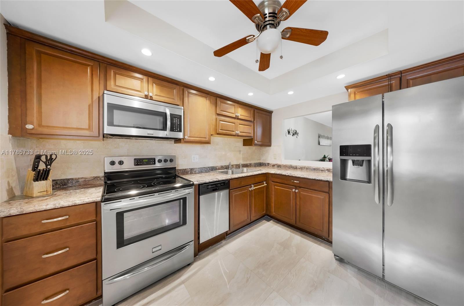 Palm Aire Pompano Beach, FL 33069 - Photo 22 of 27 a kitchen with stainless steel appliances granite countertop a refrigerator a stove a sink and dishwasher with wooden cabinet