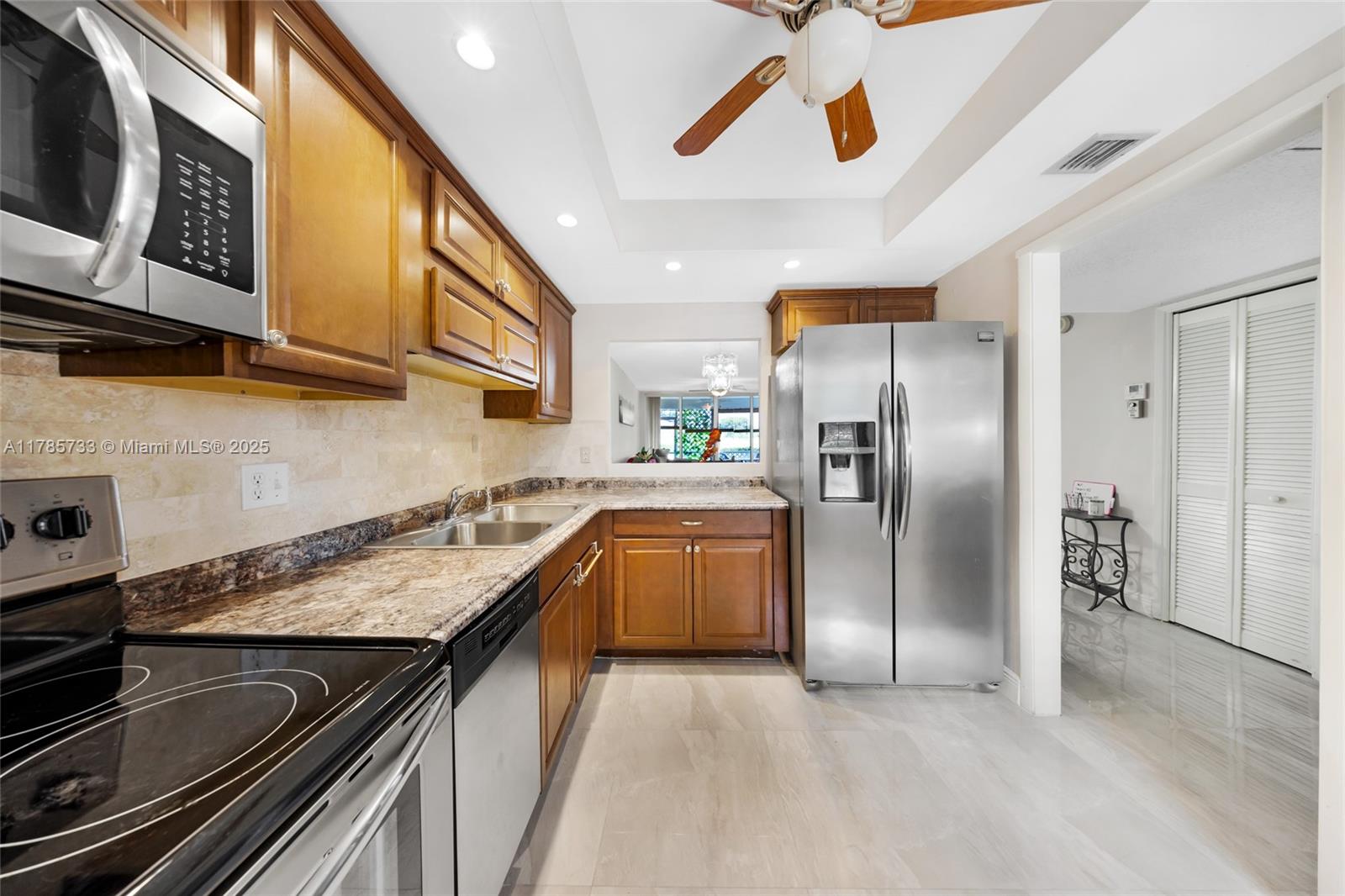 Palm Aire Pompano Beach, FL 33069 - Photo 26 of 27 a kitchen with granite countertop stainless steel appliances and wooden cabinets