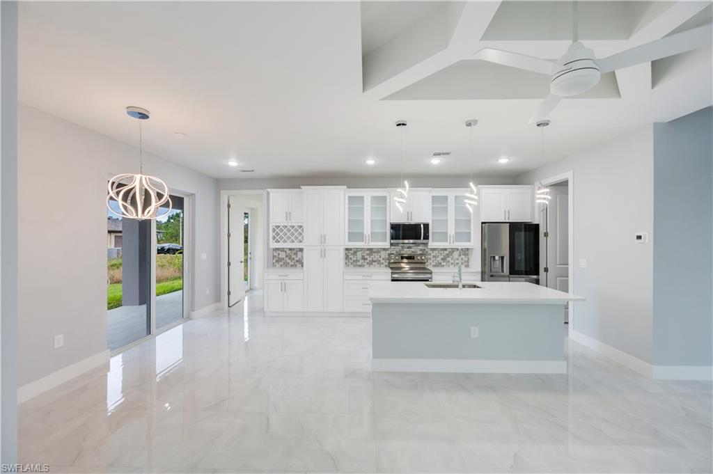 650 Kraft Street Lehigh Acres, FL 33974 - Photo 11 of 29 a large white kitchen with a refrigerator a stove and a cabinets