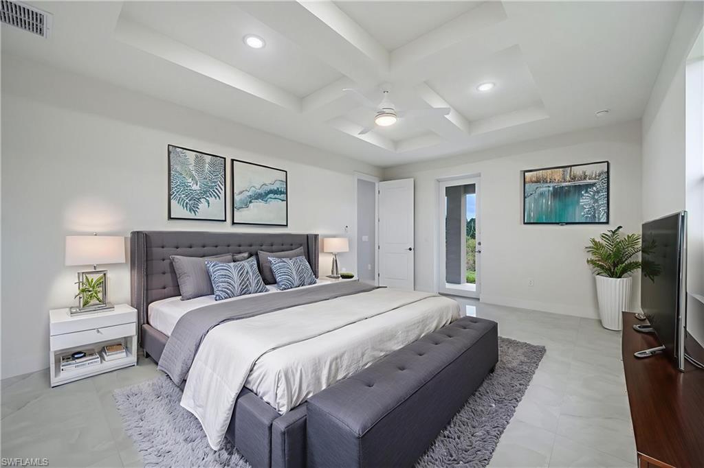 650 Kraft Street Lehigh Acres, FL 33974 - Photo 14 of 29 a spacious bedroom with a bed and a flat screen tv