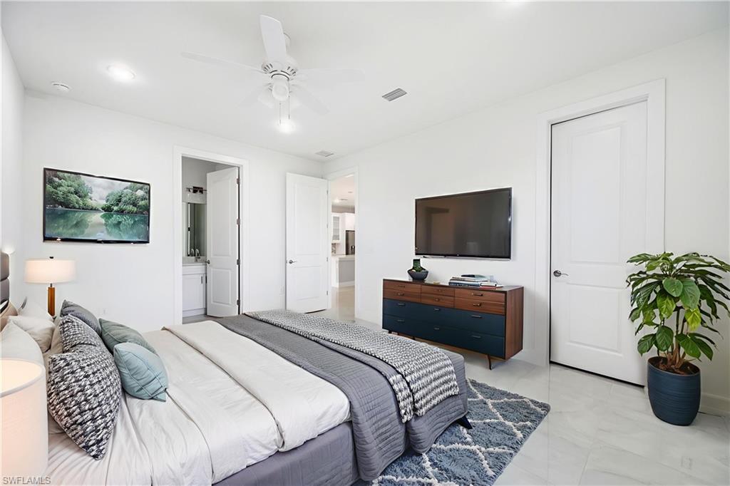 650 Kraft Street Lehigh Acres, FL 33974 - Photo 18 of 29 a bedroom with a bed and a flat screen tv