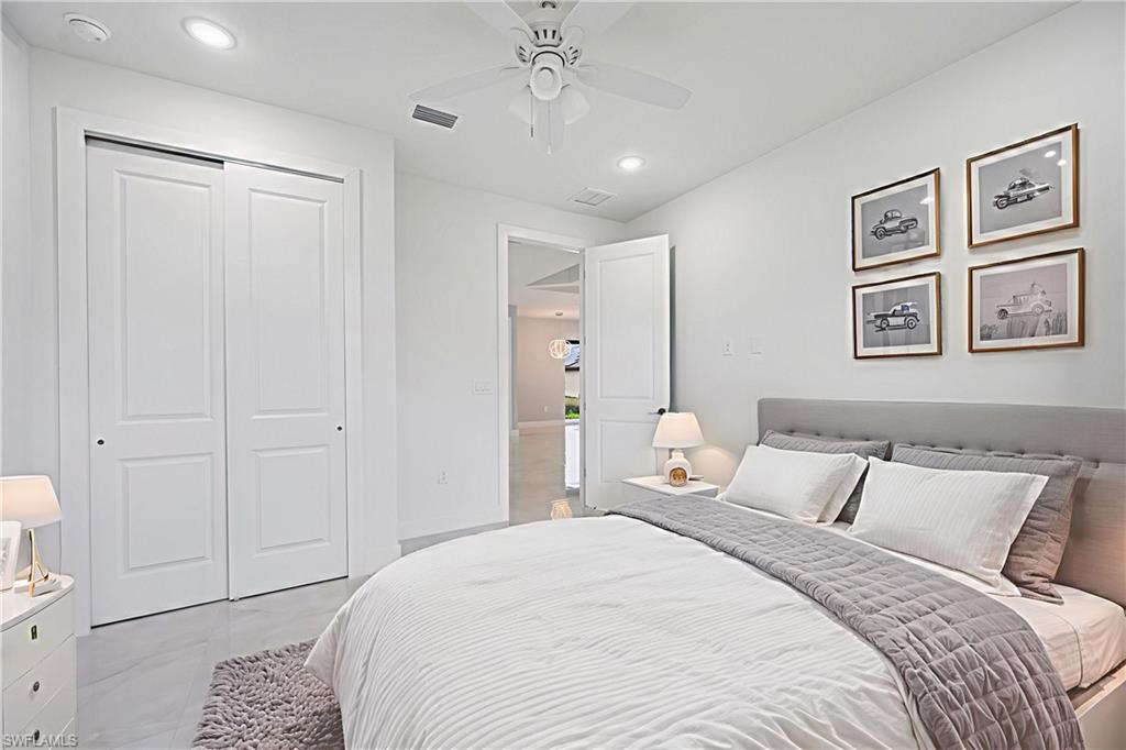 650 Kraft Street Lehigh Acres, FL 33974 - Photo 22 of 29 a bedroom with a large bed and a chandelier