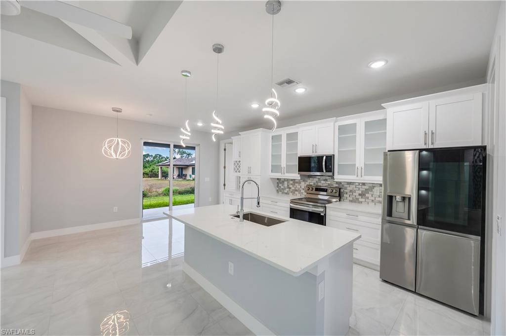 650 Kraft Street Lehigh Acres, FL 33974 - Photo 8 of 29 a kitchen with stainless steel appliances a refrigerator sink and microwave