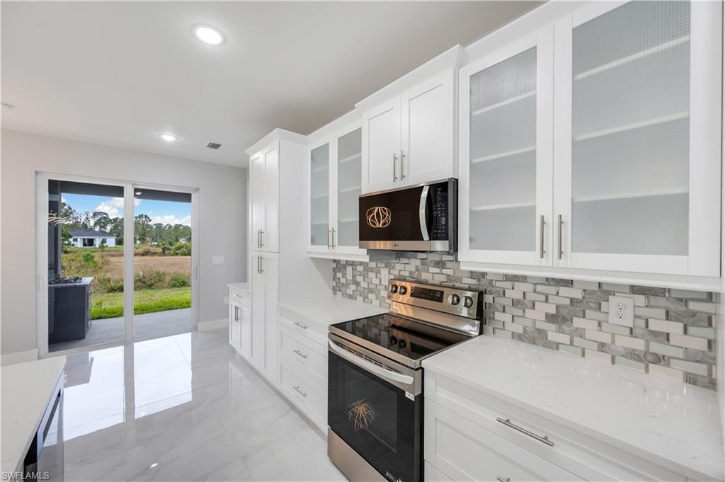 650 Kraft Street Lehigh Acres, FL 33974 - Photo 10 of 29 a kitchen with a sink a stove and microwave